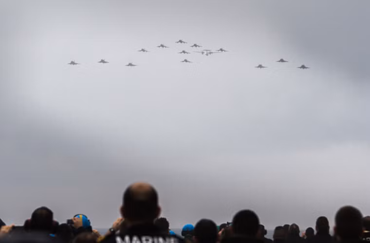 Trong ảnh là phi đội Super Etendard bay qua tàu sân bay Charles de Gaulle trong buổi lễ vào hôm 16/3 với sự tham gia của cả những chiếc Rafale M và máy bay cảnh báo sớm trên không E-2 Hawkeye.