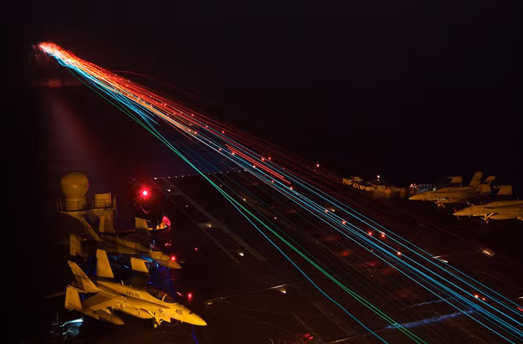 Một chiếc tiêm kích trên hạm F/A-18 của Hải quân Mỹ cất cánh trong đêm từ tàu sân bay USS Enterprise (CVN 65) trên vùng biển Ả Rập.