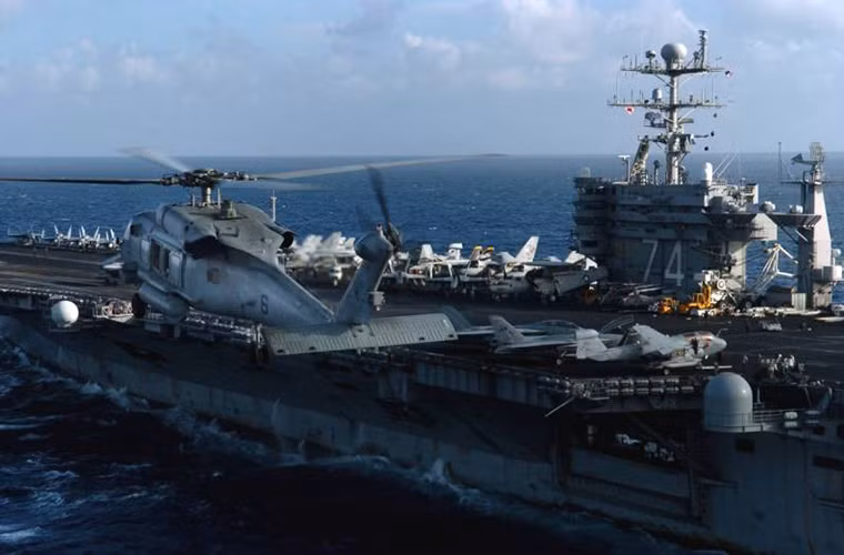 Hình ảnh một chiếc trực thăng hải quân Sikorsky SH-60 bay cạnh tàu USS John C. Stennis trong một đợt tuần tra trên biển.
