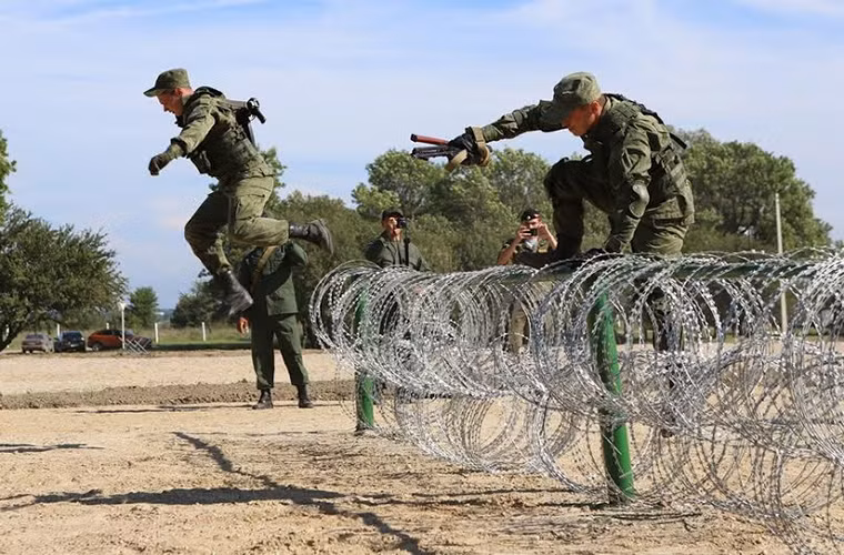 Trong ảnh là các binh sĩ thuộc lực lượng Lính thủy Đánh bộ Nga biểu diễn kỹ năng vượt hàng rào dây thép gai của mình.