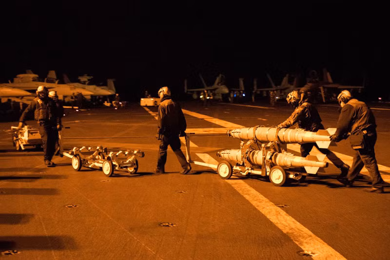 Nhân viên kỹ thuật gấp rút lắp bom cho các tiêm kích F/A-18 E/F Super Hornet trên boong tàu sân bay USS Harry S. Truman (CVN-75) đang làm nhiệm vụ tại Trung Đông. CVN-75 đang thực hiện các phi vụ không kích IS ở Syria.