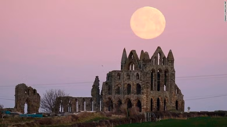 Mặt trăng mọc đằng sau tu viện Whitby ở Yorkshire, Anh.