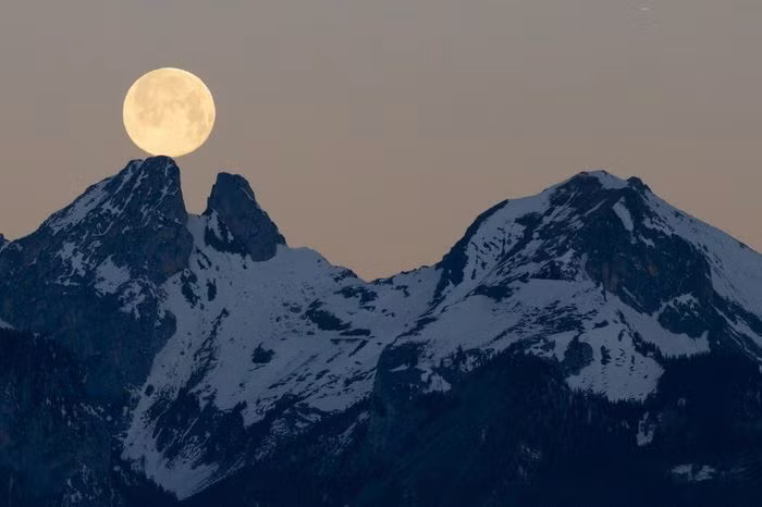 Mặt Trăng từ từ lặn sau ngọn núi Les Jumelles ở Chablais Valaisan, Thụy Sỹ.