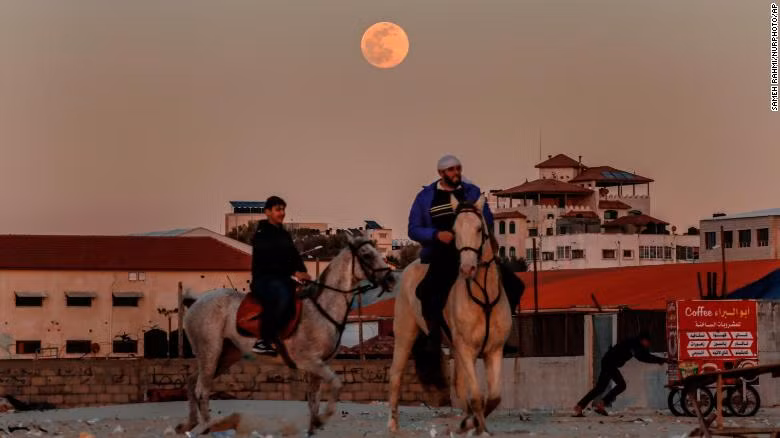 Hai anh chàng Palestine cưỡi ngựa trên bãi biển Gazakhi trăng mọc.