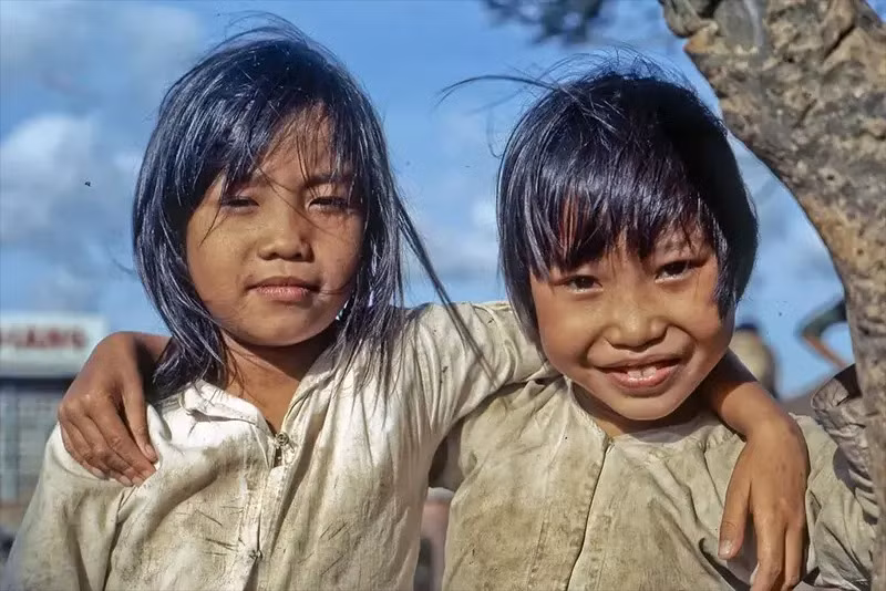 Hai em tạo dáng tinh nghịch khi thấy máy ảnh bên bờ sông Cửu Long, phía Đông Nam Mỹ Tho.