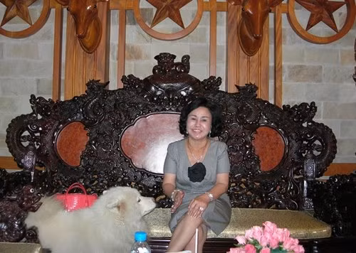 Bà Diệu Hiền bên bộ ghế gỗ hoành tráng, đắt tiền tại căn biệt thự.