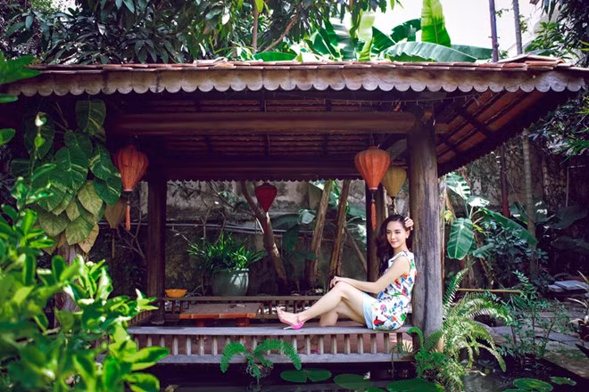 Á hậu của Hoa hậu hoàn vũ 2008 - Dương Trương Thiên Lý khiến không ít người ghen tỵ vì cô có chốn thiên đường tuyệt đẹp để sinh sống. Căn biệt thự vườn tại TP HCM của người đẹp được thiết kế hài hòa, mái ngói rêu phong, màu nâu của gỗ hòa cùng màu xanh cây lá ấn tượng.