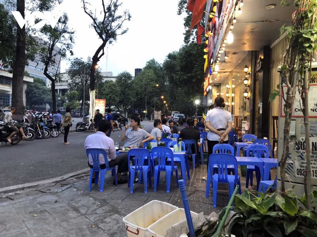 Nhiều quán bia chiều theo ý khách kê bàn trên vỉa hè cho thoáng, trong khi trong nhà còn đầy bàn trống.