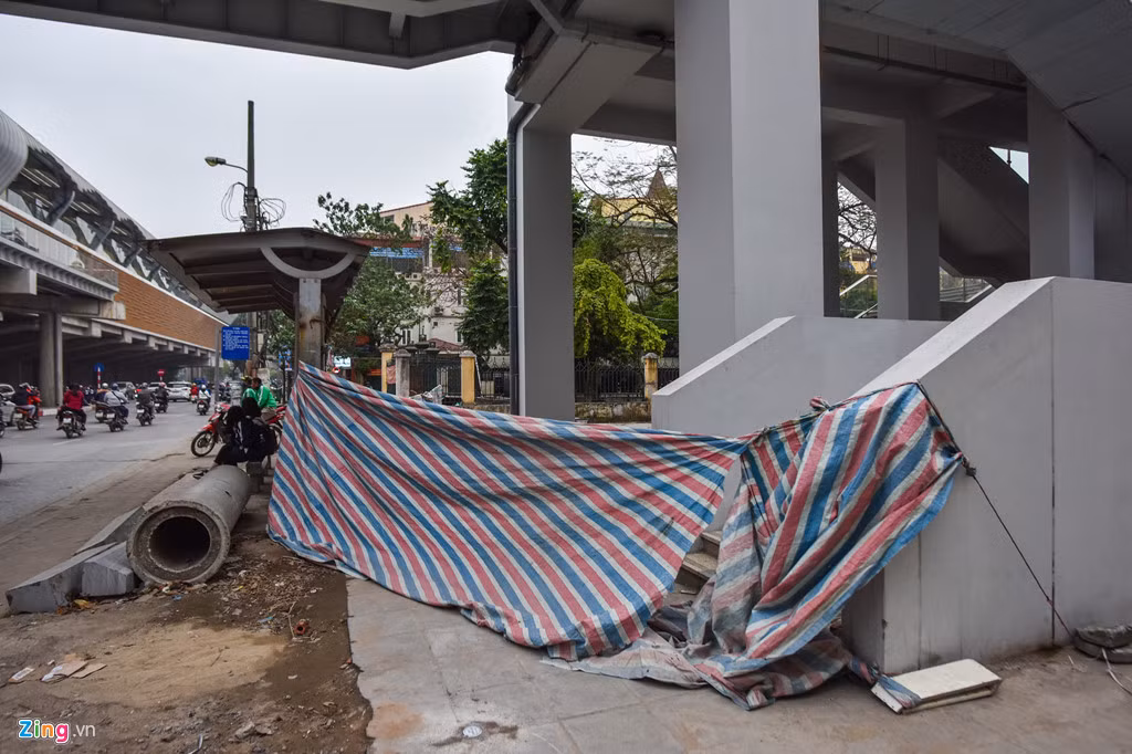 Nhà thầu xây dựng quây bạt bao quanh đường dẫn lên ga Láng khiến cho khu vực này nhếch nhác, nguy hiểm cho người tham gia giao thông.