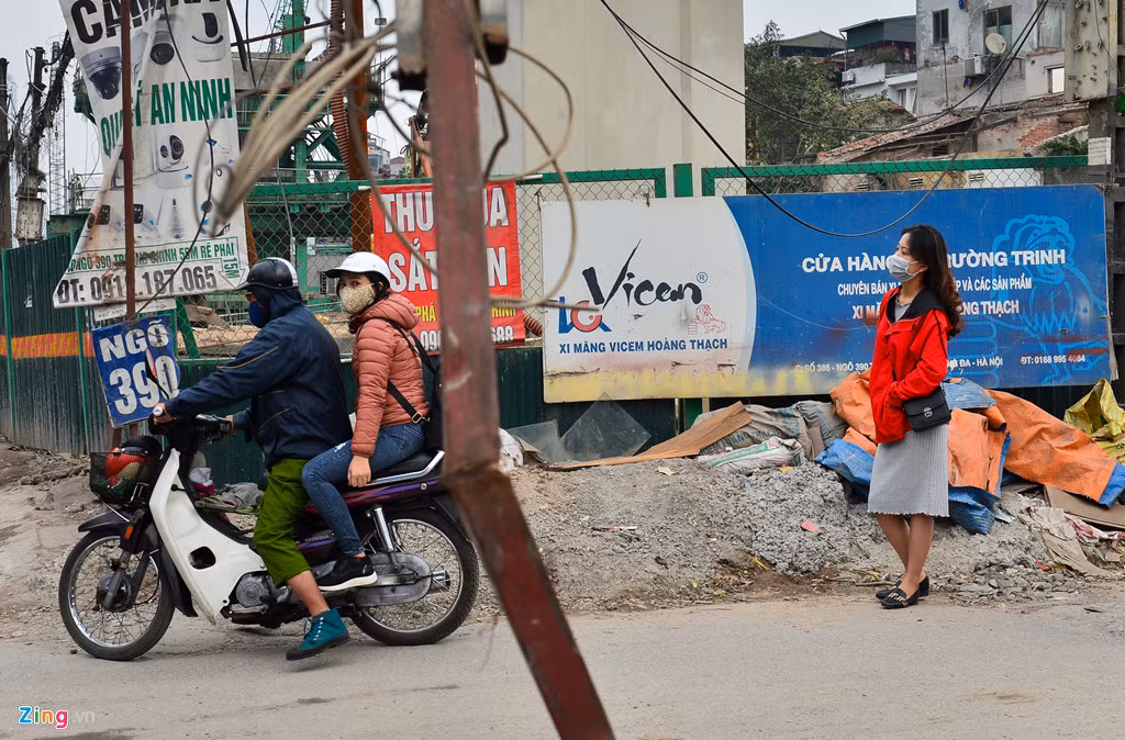 Nguyễn Phương Anh (áo đỏ) sinh viên trường Cao đẳng Du lịch và Thương mại đứng đợi xe ôm công nghệ nhưng 30 phút lái xe vẫn chưa tới vì tắc đường. Phương Anh cho biết có hôm chị mặc quần áo trắng, vừa mới ra đường đã bị ôtô đi qua vũng nước bắn cho bẩn hết.