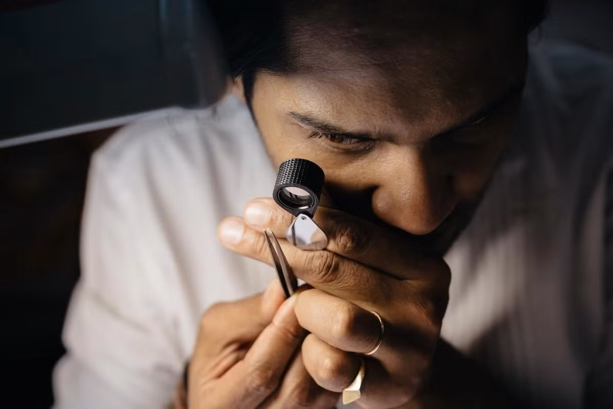 Một người thợ đang kiểm tra viên kim cương tại cơ sở Tallin ở Jaipur. Ảnh: Theguardian
