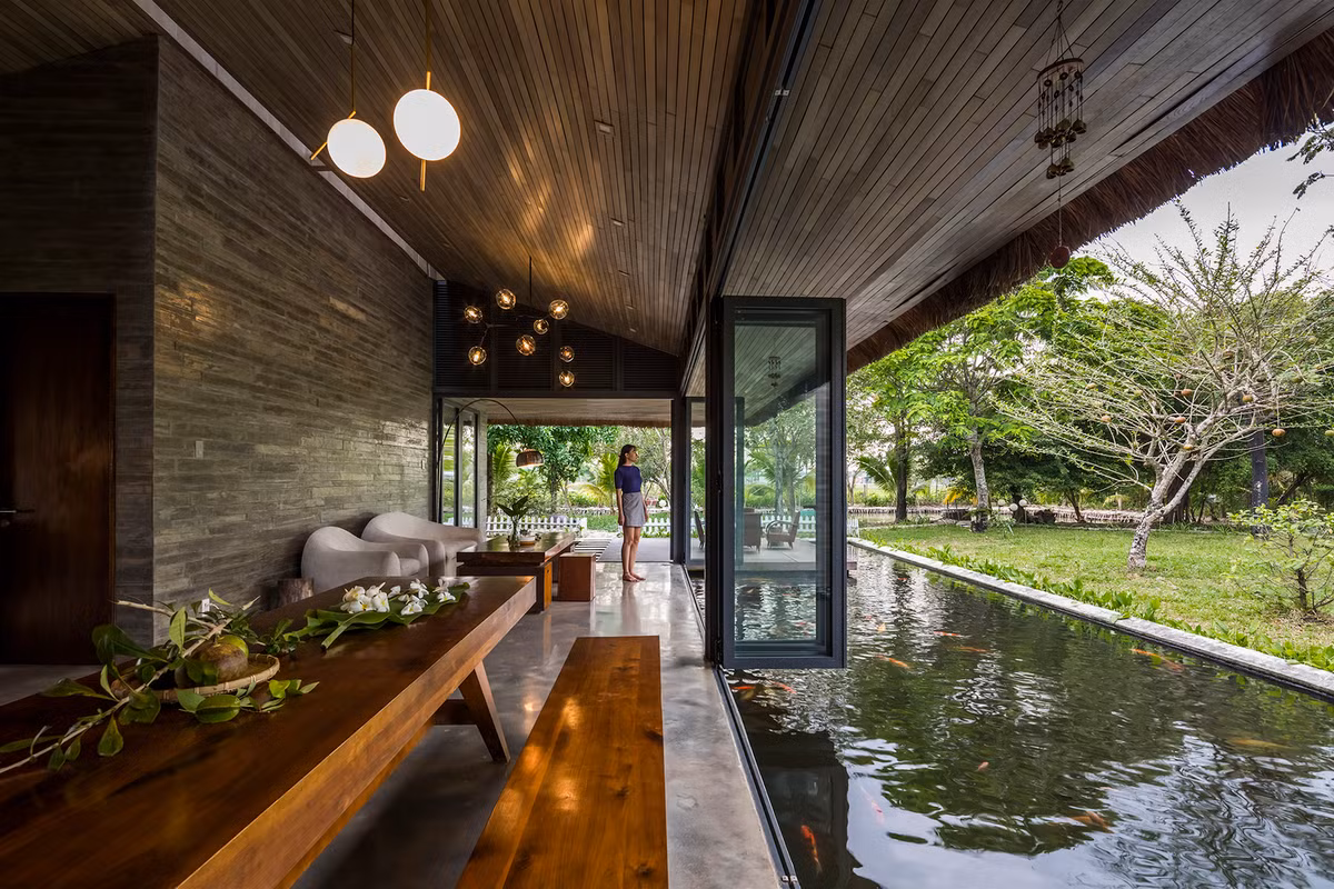 Một hồ nước lớn nằm sát sàn và “ôm trọn” hai mặt ngôi nhà, vừa tạo cảnh quan xanh mát, gần gũi thiên nhiên, vừa giúp căn nhà điều tiết vi khí hậu hiệu quả. Ảnh: Hiroyuki Oki