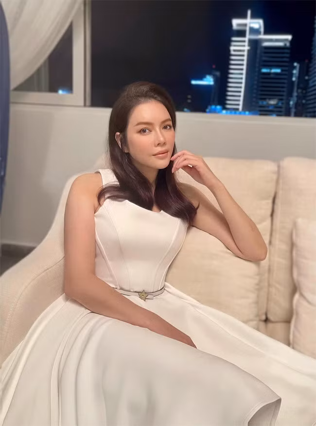 Lý Nhã Kỳ diện chiếc váy xòe màu trắng đơn giản khoe eo thon rồi chụp một kiểu ảnh trong phòng khách làm kỷ niệm.