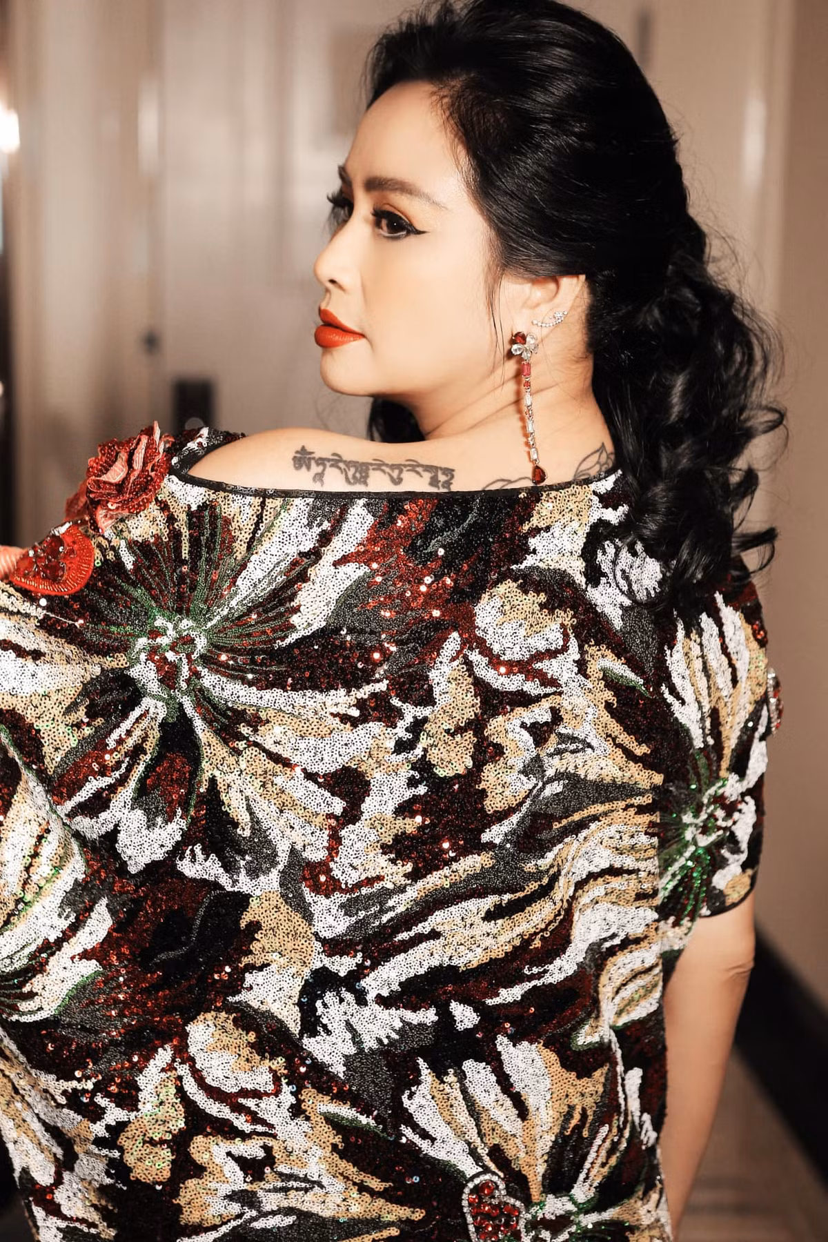 Từ bức ảnh mới nhất của chị, có thể thấy Thanh Lam xăm bàn tay cầm nhành hoa sen và chùm hoa mẫu đơn ở 2 bên bả vai, dọc cột sống là một dòng chữ bí ẩn.