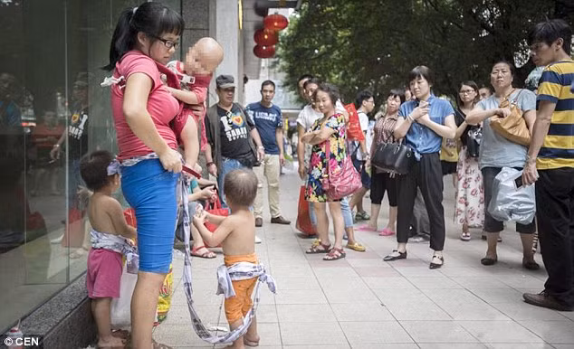 Cảnh tượng người mẹ dùng dây vải buộc hai đứa con cởi trần đã thu hút sự quan tâm của rất nhiều người qua đường bởi vì theo chính sách sinh đẻ ở Trung Quốc, phần lớn các cặp vợ chồng chỉ có một con.