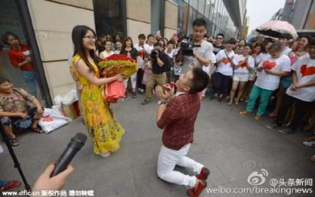Zhang Liang đã mời gần 100 bạn bè và người thân chứng kiến anh cầu hôn bạn gái giữa đường phố ở Thành Đô, tỉnh Tứ Xuyên, Trung Quốc.