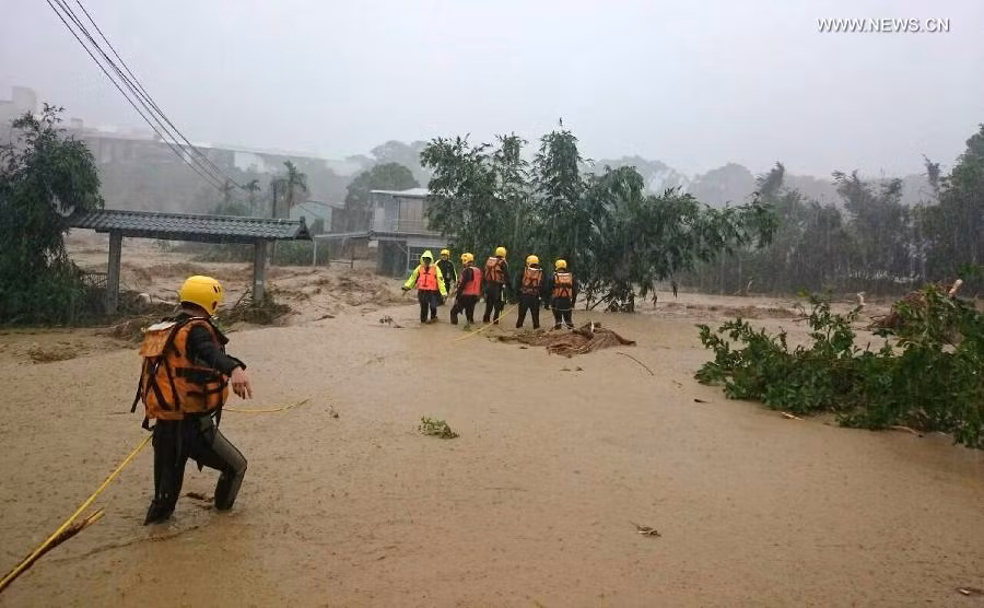 Nhân viên cứu hộ tìm kiếm nạn nhân mắc kẹt trong mưa lũ ở Tân Bắc.