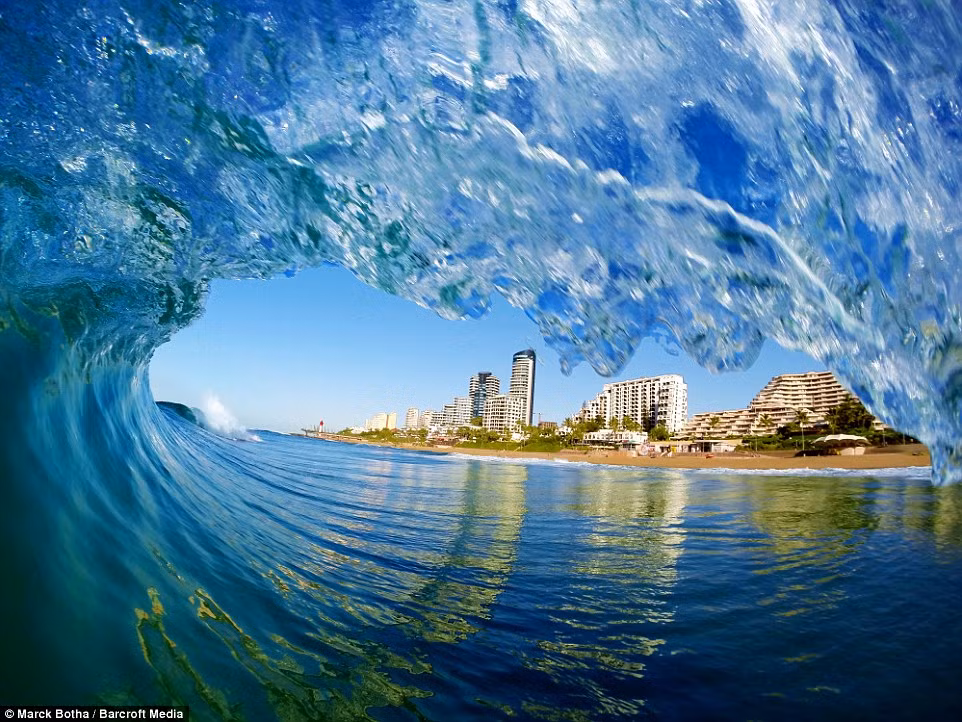 Khu nghỉ dưỡng Umhlanga tại thành phố biển Durban nhìn từ dưới vòm một cơn sóng cuộn vào bờ biển.