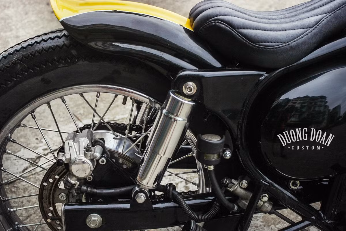 Với cặp phuộc nhỏ, bản độ Estrella này đã đi theo hướng bobber softail, khiến người lái dễ chịu hơn so với việc ngồi trên những chiếc hardtail không giảm xóc sau. Trong khi bánh trước được trang bị phanh đùm thì ở phía sau, DuongDoan Design đã sử dụng phanh đĩa cho Estrella.