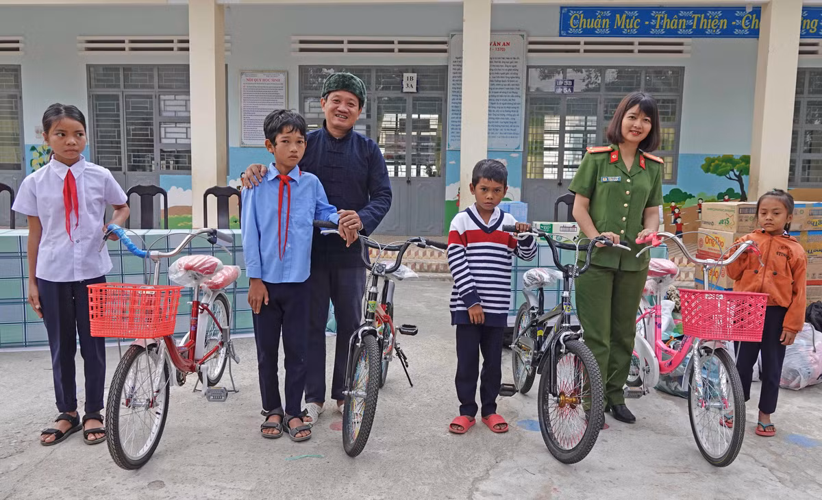 Bà Ksor H'bơ Khắp cùng ông Đoàn Ngọc Hải trong một lần tặng xe đạp cho học sinh nghèo tại Ayun Pa.