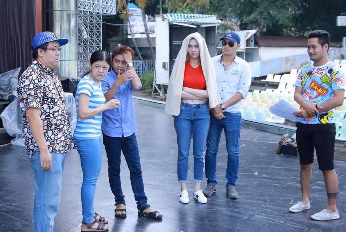 Có gì dùng đó, người đẹp vớ ngay chiếc khăn bông để tránh nắng khi tập cùng bạn diễn ngoài trời. Ảnh: FB Ngọc Trinh.