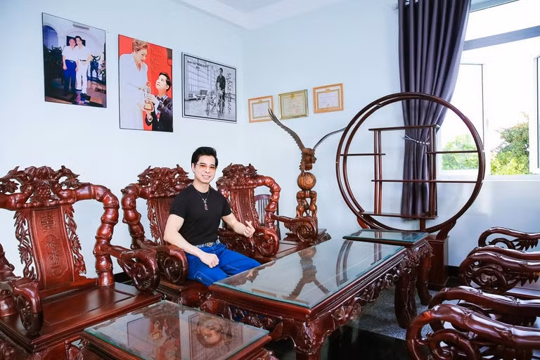 Trong phòng khách kê bộ bàn ghế gỗ đồ sộ, chạm khắc tỉ mỉ.