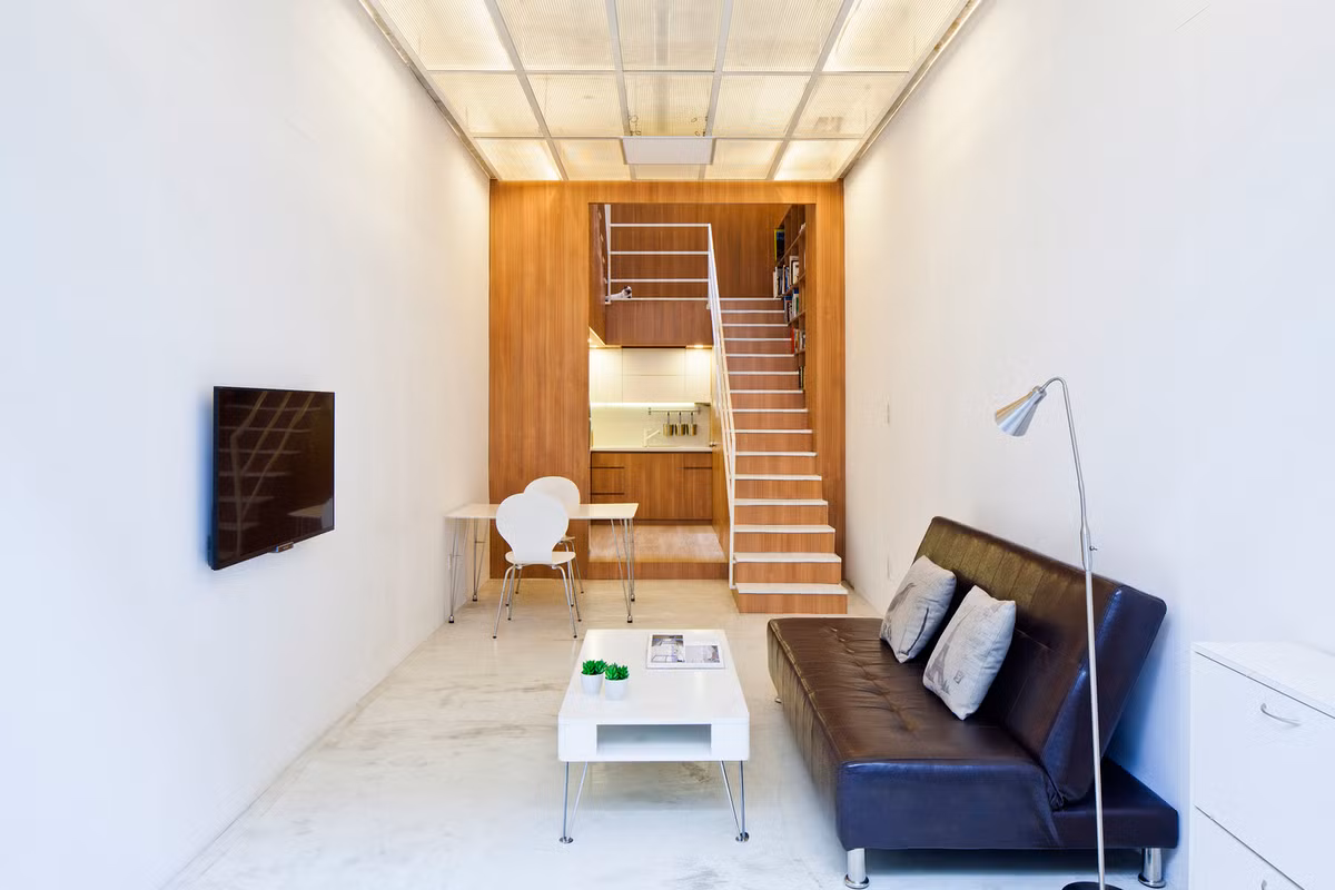 Không gian phòng khách bố trí đơn giản với ghế sofa dài cùng bàn trà có chân giúp không gian thoáng đãng hơn.