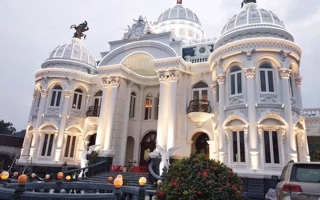 Mặt tiền biệt thự thiết kế với những cột đá khổng lồ, ba mái vòm lớn. Trên đỉnh tòa nhà còn có những bức tượng mạ vàng. Ảnh: Odditycentral