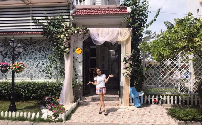 Vy Oanh hớn hở chụp ảnh ở sân trước với cây xanh mát mắt.