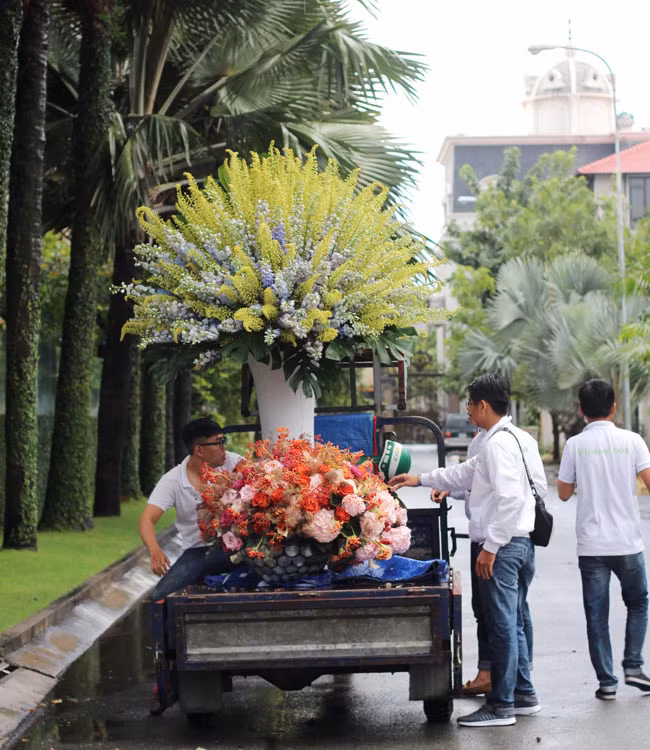 Bình hoa này cao trên 2m nên phải cần đến 4 nghệ nhân cắm hoa chuyên nghiệp mới cắm xong. Để vận chuyển các bình hoa này thì phải huy động xe 6 người phụ giúp mới có thể khiêng được. (Ảnh: Dân Việt).