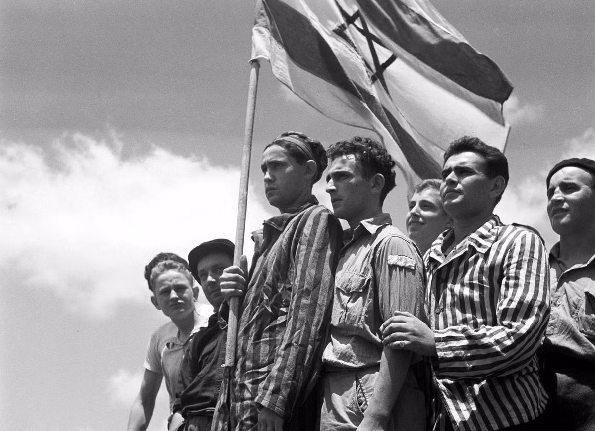 Những tù binh Do Thái trong các trại tập trung dương cao ngọn cờ Israel sau khi họ được giải phóng. Nguồn ảnh: Theatlantic.