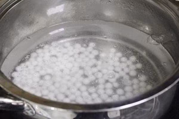 Đặt một nồi nước lên bếp, cho trân châu vào luộc cho đến khi trân châu nổi lên mặt nước, tức là trân châu đã chín. Trong khi luộc,lắc nhẹ chảo để trân châu chín đều và không bị dính chảo. Ảnh: Amthuc365.
