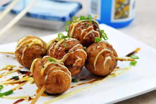 Bánh bạch tuộc Takoyaki. Đây là một loại bánh bao của Nhật có nhân bạch tuộc và trứng. Đây cũng là món bánh không thể thiếu trong các dịp lễ hội ở Nhật. Nguyên liệu chính của món bánh này là bột mì, bột dashi, bột tenkasu, trứng gà, hành chua, bắp cải, gừng và bạch tuộc. Sau khi được nướng chín, bánh sẽ được ăn kèm sốt Takoyaki và mayonnaise. Ảnh: zing