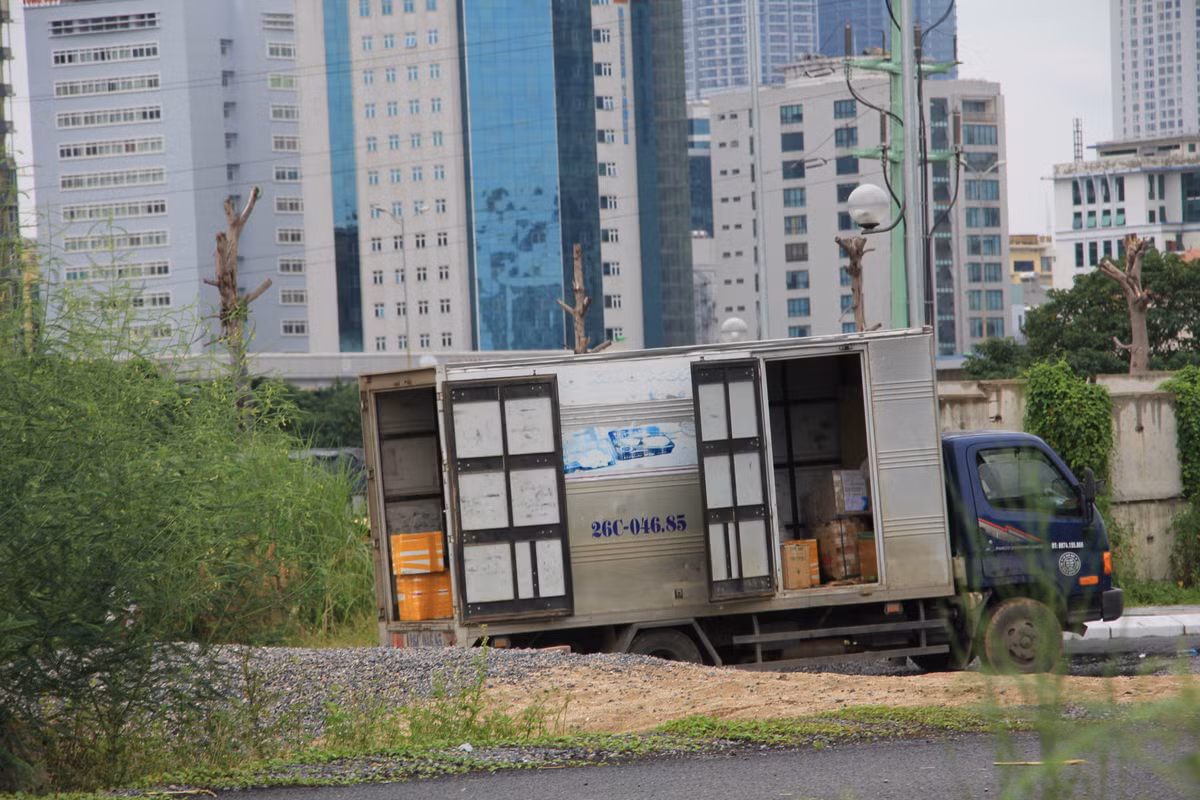Chiếc xe vẫn nằm chờ chủ hàng ra lấy. Nếu không có sự chỉ đường tận tình của lái, phụ xe thì chủ hàng khó có thể tìm được bãi đất rậm rạp cây dại này, mặc dù nằm sát đường Phạm Hùng (quận Cầu Giấy).