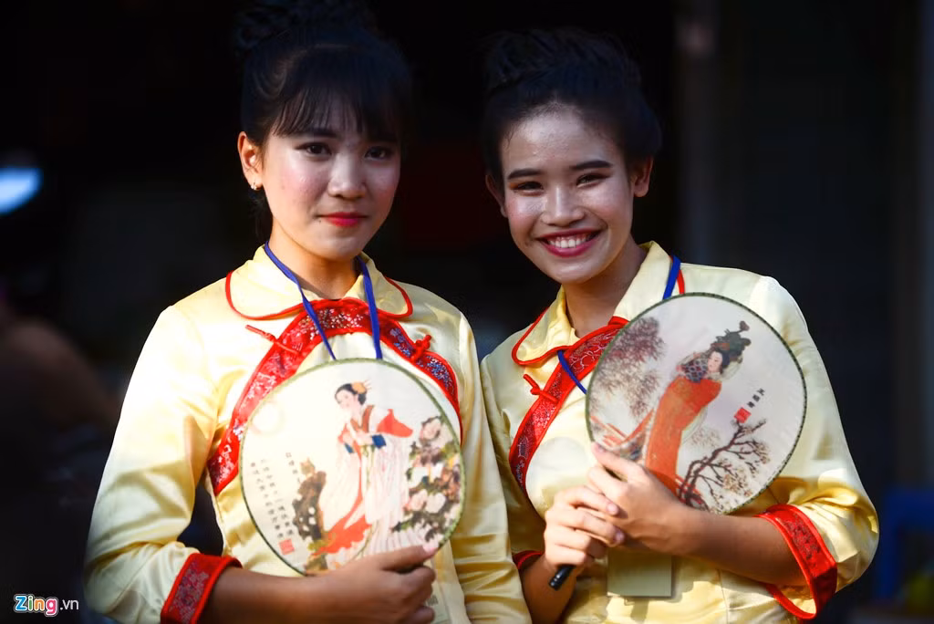Hai cô gái mang theo bên mình chiếc quạt có hình họa tiên nữ.