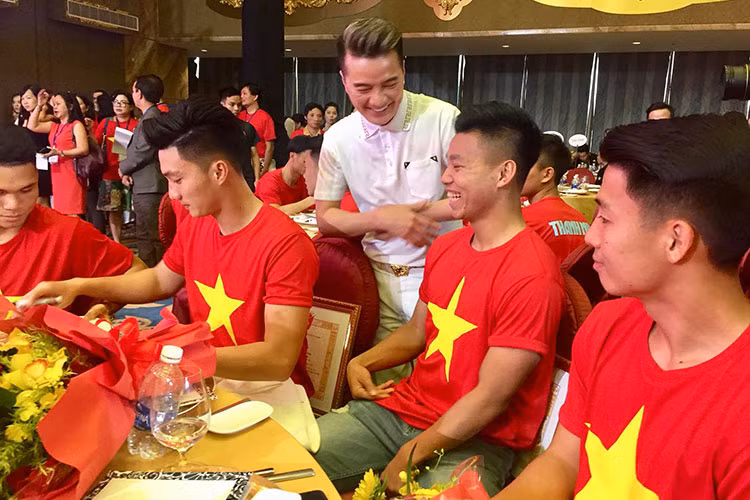 Các cầu thủ của U23 Việt Nam vui vẻ ký tặng lên chiếc áo khoác của Đàm Vĩnh Hưng.