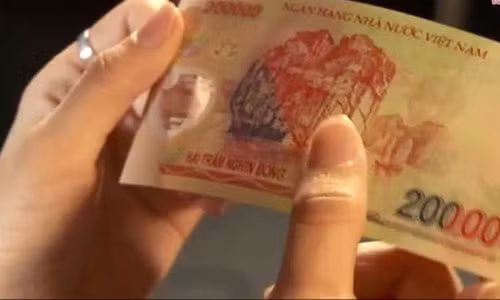 Hình ảnh kiểm tra tiền giả - thật - Ảnh chụp từ clip của báo Tuổi Trẻ.