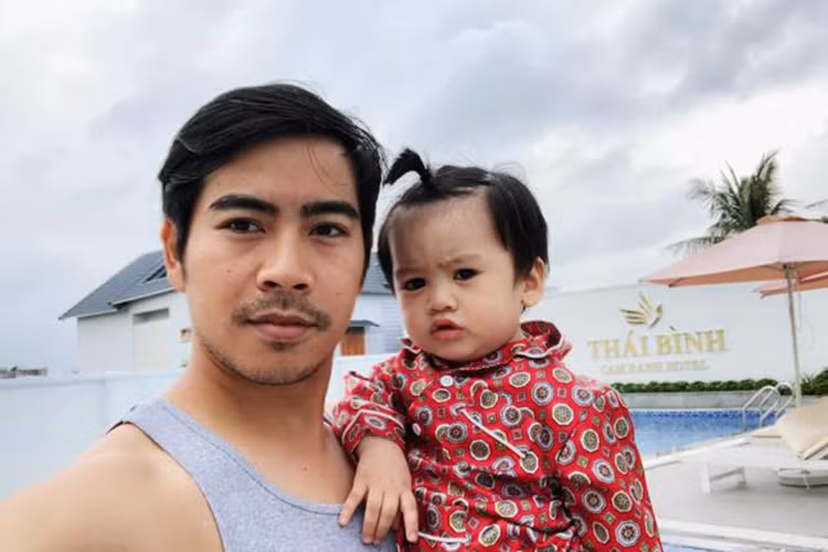 Hình ảnh bé Phôi được cột tóc đáng yêu bên bố mẹ trong một chuyến đi chơi.