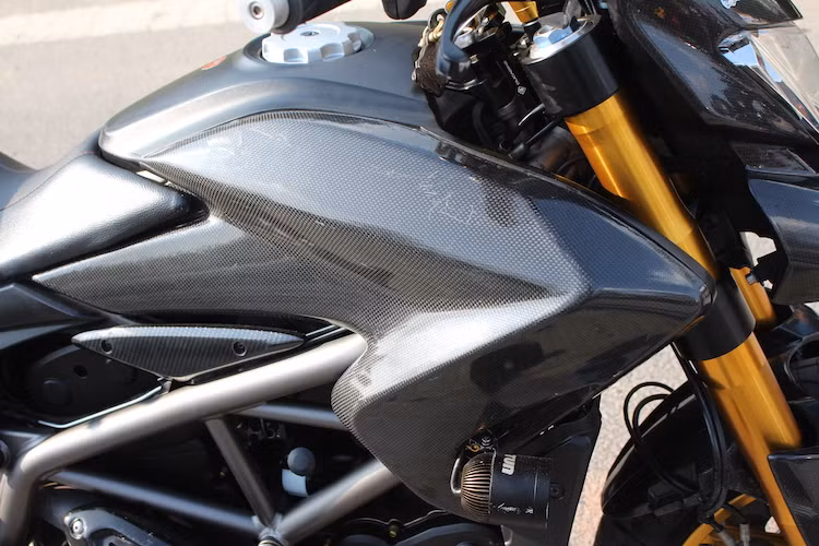 Không chỉ có dàn đầu độ vỏ carbon, các tấm ốp hai bên bình xăng của Hypermotard cũng đã được chủ nhân thay bằng sợi carbon. Nằm ở hai bên thân xe là cặp đèn LED Tun giúp "đánh bật bóng đêm" trong những chuyến "phượt" buổi tối.