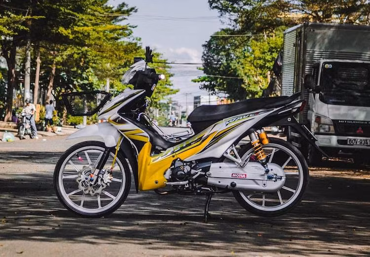 Để mừng xuân Đinh Dậu, một biker tại miền Nam đã "dọn" lại chiếc Wave S 110 của mình đầy bắt mắt theo phong cách kiểng Thái Lan với hàng loạt phụ tùng có giá trị cao. Điểm nhấn đầu tiên của chiếc xe là dàn áo màu trắng tinh khiết với điểm nhấn là bộ tem vàng tươi bắt mắt như sắc hoa mai mùa Tết.