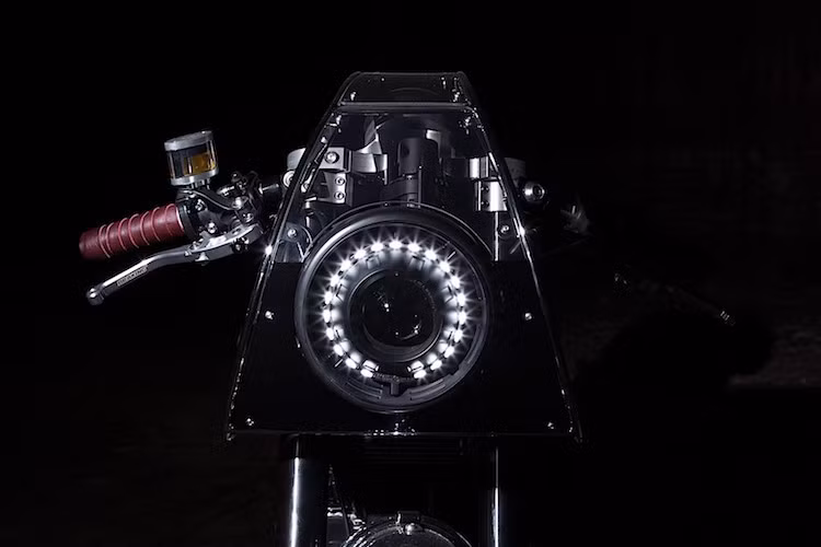 Theo phong cách cafe racer, chiếc xe đã có bộ quây gió phía trước bao xung quanh đèn pha LED kết hợp bi cầu projector. Tuy nhiên thay vì có dáng lồi như những bản độ cafe khác, bộ quây này vuốt thon dần theo trục dọc xe. Cặp tay clip-on thay thế cho ghi-đông nguyên bản của Scrambler, phía trên tay lái là bình dầu Rizoma Next, cặp tay phanh/côn Braking và tay nắm cuốn từ da kiểu cổ điển.