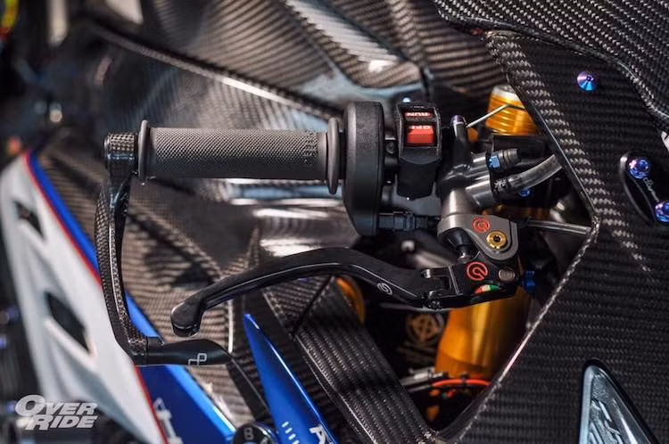 Trong khi đó, ở bên phải là sự xuất hiện của cùm phanh Brembo Rossi đẳng cấp, được bảo vệ bởi càng Lightech bằng sợi carbon nhẹ nhưng cứng cáp. Hai bên thân của chiếc xe cũng được bảo vệ trong trường hợp tai nạn nhờ cặp chống đổ Motovation, trong khi dàn quây gió được trang trí theo phong cách phiên bản HP4.