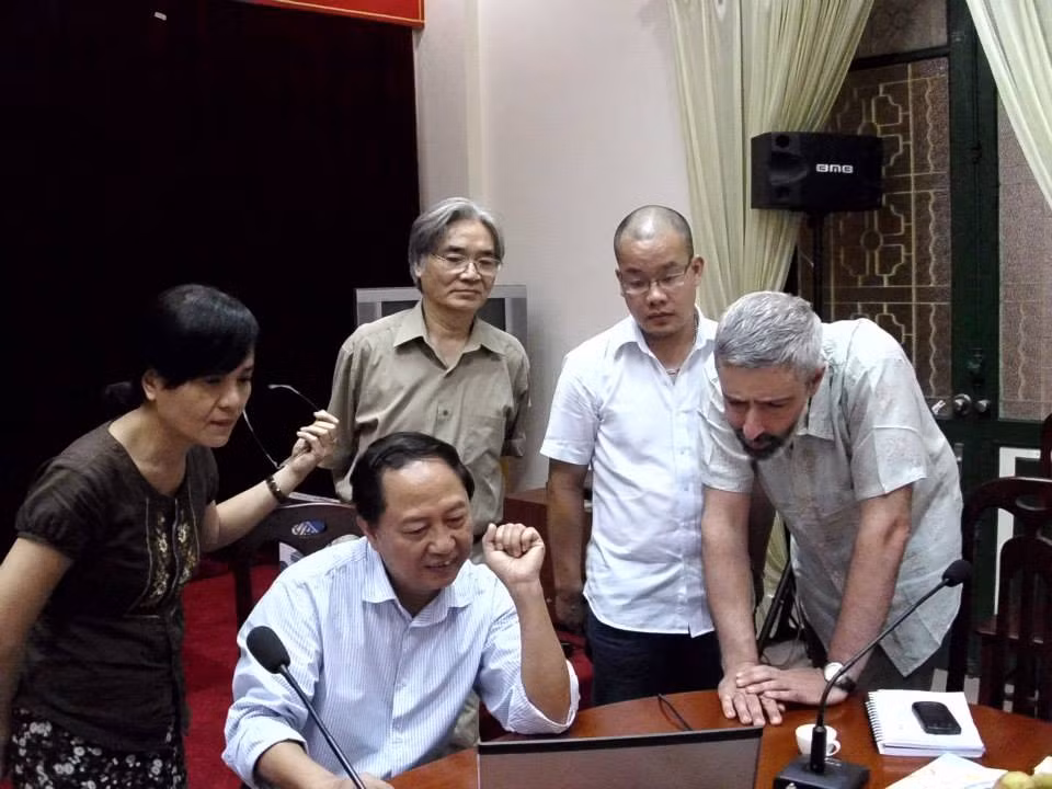 GS.TS Nguyễn Văn Lợi (hàng sau, đeo kính) trao đổi với chuyên gia nước ngoài nhân việc bàn về phần mềm soạn thảo Từ điển tiếng Việt. Ảnh: Văn Hiến Việt Nam