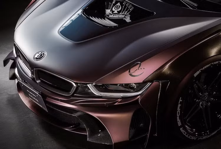 Với gói độ EVO, toàn bộ phần cản trước của i8 đã được hãng Energy Motor Sport thay mới hoàn toàn, với những cánh khí động học độc đáo và phần lưới hút gió rộng hơn nhiều so với xe zin. Nằm phía trên nắp ca-pô của xe là hình ảnh những lá "át chủ bài" gắn với nhân vật Joker.