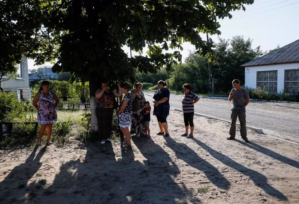 Mọi người nghe đài phát thanh Ukraine trên một vùng đất trống ở làng Grechishkino. Nhiều cơ sở hạ tầng phục vụ phát thanh, truyền hình ở miền đông Ukraine hiện do phe ly khai kiểm soát hoặc bị phá hủy trong các cuộc giao chiến.