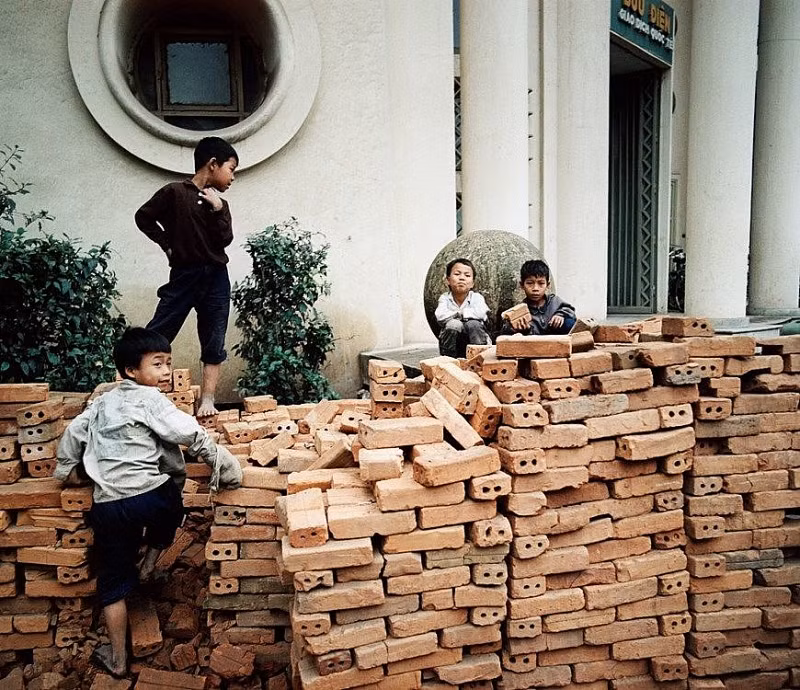 Một nhóm trẻ em chơi đùa cạnh một đống gạch.