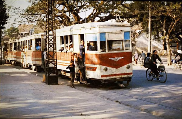 Một chuyến tàu điện chật kín hành khách. Khi tàu chưa chạy, một số trẻ em tò mò chạy lên xe điện xem phương tiện giao thông này như thế nào.