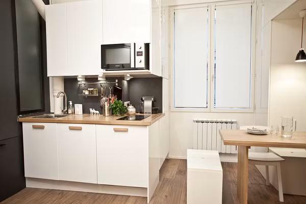  2. Căn hộ 18m2 siêu tiện nghi nhờ thiết kế thông minh trong từng góc nhỏ Dù chỉ vỏn vẹn 18m2, thế nhưng căn hộ mini này có đủ giường ngủ, bàn ăn, bếp, khu vệ sinh. Để có được điều này, các kiến trúc sư đã tận dụng tối đa không gian tường nhà để làm nơi lưu trữ. Các ngăn tủ lớn âm tường và nội thất gắn tường trong căn hộ đã hoàn thành xuất sắc nhiệm vụ lưu trữ đồ đạc cần thiết đồng thời lại đảm bảo được sự gọn gàng, đẹp mắt.