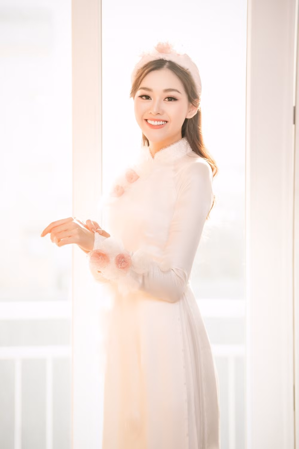Vào ngày lễ rước dâu, Top 8 Hoa hậu Quốc tế 2019 - Tường San diện áo dài hồng thướt tha, lựa chọn tông trang điểm nhẹ nhàng khoe vẻ đẹp trong veo. Trong những thước ảnh hiếm hoi của ngày lễ trọng đại nhất đời, cô dâu Nguyễn Tường San khiến fan ghen tỵ với chiếc nhẫn kim cương.