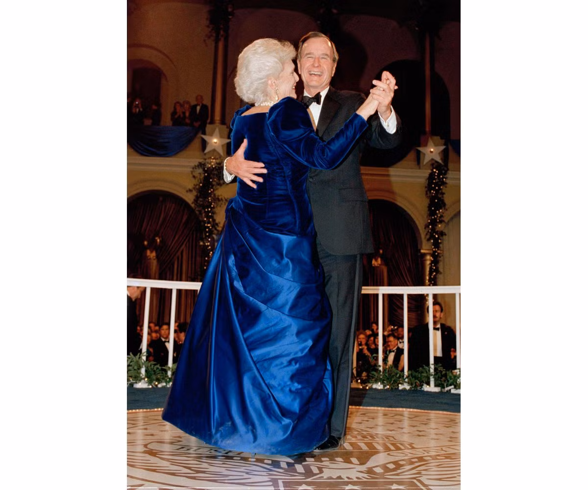 Đệ nhất phu nhân Barbara Bush mặc chiếc váy màu xanh nổi bật của nhà thiết kế Arnold Scaasi trong buổi tiệc khiêu vũ trong ngày nhậm chức của Tổng thống George H. W. Bush.